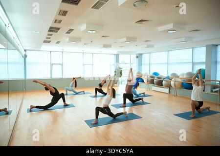Les gens debout dans Ashta Chandrasana équilibrant asana avec les mains serrées au-dessus de la tête Banque D'Images