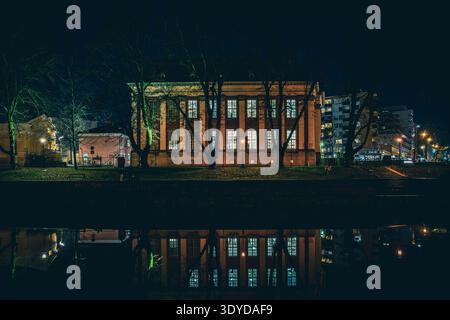 Paysage urbain nocturne le long de la rivière aura (Aurajoki) avec des bâtiments reflétant dans l'eau, Turku, Finlande. Banque D'Images