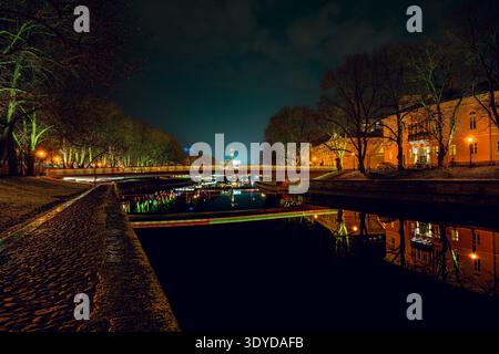 Paysage urbain nocturne le long de la rivière aura (Aurajoki) avec des bâtiments reflétant dans l'eau, Turku, Finlande. Banque D'Images