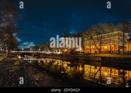 Paysage urbain nocturne le long de la rivière aura (Aurajoki) avec des bâtiments reflétant dans l'eau, Turku, Finlande. Banque D'Images