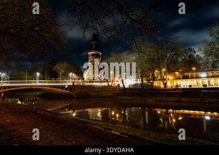Paysage urbain nocturne le long de la rivière aura (Aurajoki) avec des bâtiments reflétant dans l'eau, Turku, Finlande. Banque D'Images