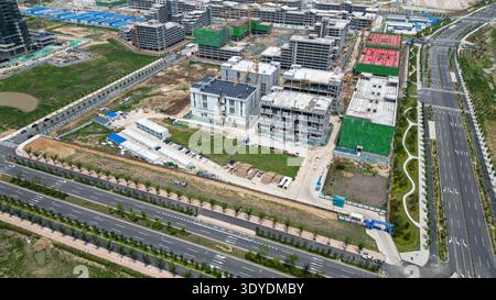 Un regard aérien sur un chantier de construction résidentielle avec plusieurs immeubles d'habitation, l'équipement du site et les chemins d'infrastructure. L'image transmet le réel Banque D'Images