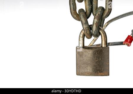 La photographie capture en détail un cadenas verrouillé altéré relié à une chaîne industrielle. La vue rapprochée met l'accent sur la durabilité et la sécurité. Banque D'Images