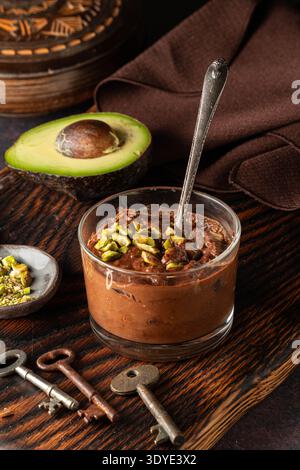 Mousse d'avocat au chocolat dans un dessert en verre sur fond sombre. Banque D'Images