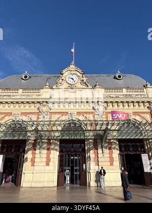 Gare de Nice-ville, Nice, France. Architecture belle époque ornée avec horloge et drapeau français au-dessus de l'entrée principale. Banque D'Images