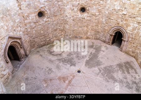 Plan en grand angle de la cour intérieure de Castel del Monte. Le revêtement de sol symétrique converge vers le centre, encadré par des murs de calcaire imposants avec d Banque D'Images