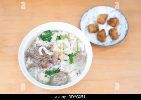 Soupe de nouilles au boeuf de style cantonais avec boulettes sur une table en bois à Guangzhou Banque D'Images