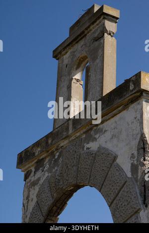Ruines du bâtiment historique de l'usine de soie italienne à Rhodes, en Grèce, montrant une voûte en pierre altérée et une architecture détériorée dans un ciel bleu. Banque D'Images