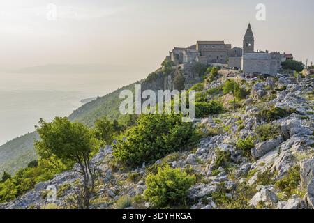 Petit village de pêcheurs (Lubenice) construit sur les rochers au-dessus de la mer avec une vue sur la mer par une journée ensoleillée au coucher du soleil sur l'île de Cres, Croatie Banque D'Images