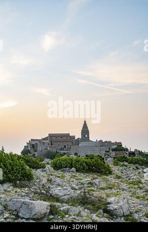 Petit village de pêcheurs (Lubenice) construit sur les rochers au-dessus de la mer avec une vue sur la mer par une journée ensoleillée au coucher du soleil sur l'île de Cres, Croatie Banque D'Images