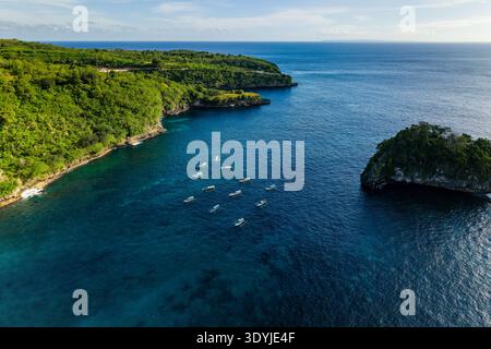 Tir par drone surplombant des falaises verdoyantes et un océan turquoise à Crystal Bay, Nusa Penida Banque D'Images