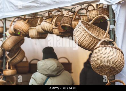 Groupe de paniers en osier vides suspendus dans une tente ou un étal à vendre dans un marché de rue ou une foire traditionnelle en hiver ou au printemps Banque D'Images