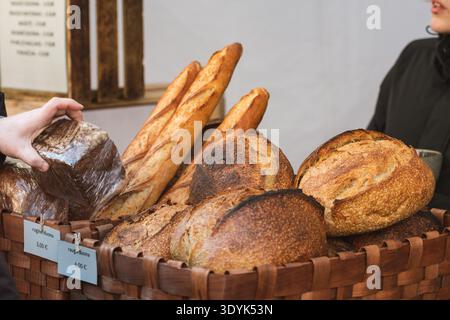 Divers types de pain fraîchement cuits exposés dans des paniers en osier dans une boulangerie ou un marché alimentaire de rue Banque D'Images