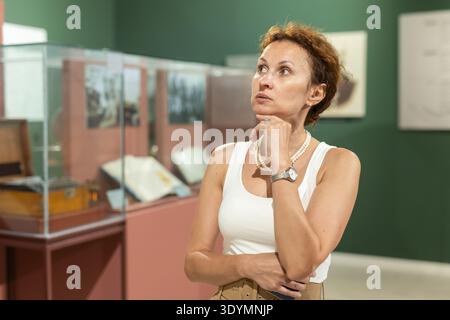Femme d'âge moyen regardant les expositions dans le musée historique Banque D'Images