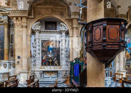 Vue sur la nef avec la majestueuse chaire en bois sculptée par Giorgio Aver et l'autel baroque de l'Immaculée conception. Cathédrale de Gallipoli i Banque D'Images