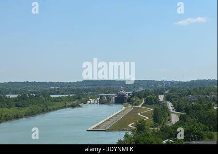 Thorold, ON, Canada - 10 août 2023 : ce paysage montre le canal Welland qui coule à travers un paysage verdoyant par une journée ensoleillée et lumineuse. Banque D'Images