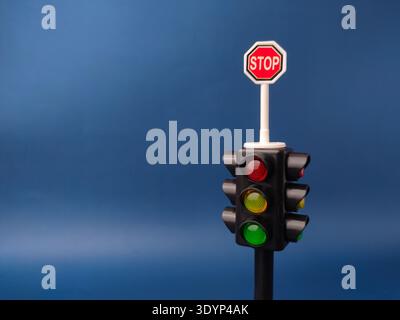 Cet article est un feu de circulation simulé de jouet pour enfants avec un panneau d'arrêt sur un fond bleu. Banque D'Images
