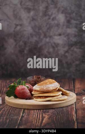 Crêpes aux fraises et au chocolat sur une table en bois Banque D'Images