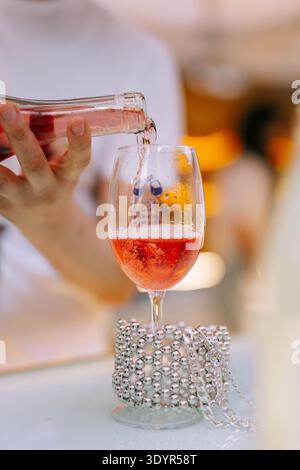Gros plan d'un verre de vin rosé réfrigéré avec des glaçons et de la condensation sur le verre pendant le festival des Journées du vin d'Erevan à Erevan. Banque D'Images