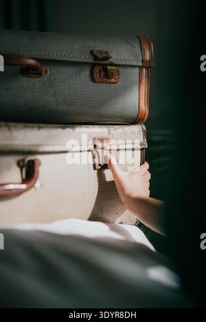 Poignées poignée de valise vintage. Une lumière douce met en évidence la texture usée des valises empilées. L'humeur suggère un souvenir de voyage ou un début d'aventure. Idéal pour Banque D'Images