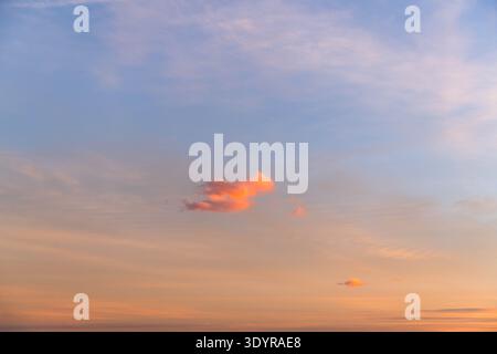 Ciel de coucher de soleil pastel doux avec de petits nuages luisants Banque D'Images