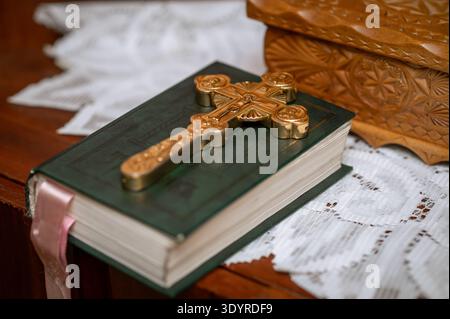 Gros plan du crucifix en métal antique sur livre en relief et cercueil décoratif en bois avec sculpture traditionnelle plan conceptuel de l'artisanat hérita Banque D'Images