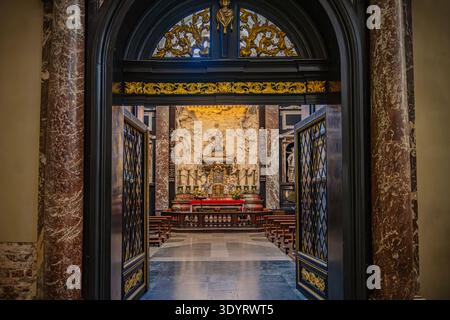 Une vue à travers une porte ornée de bois sombre et d'or dans la magnifique chapelle baroque de nouveaux Casimir à l'intérieur de la basilique de la cathédrale de Vilnius. Banque D'Images