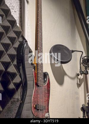 Guitare basse électrique et microphone avec filtre pop prêt pour la session d'enregistrement dans un studio de musique professionnel. mur de mousse acoustique crée créatif et Banque D'Images