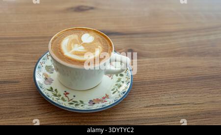 Café cappuccino avec Heart Latte art préparé par un barista servi dans une tasse de café Banque D'Images