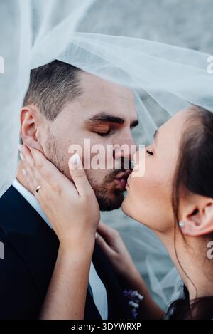 Jeune couple de mariage s'embrassant, debout dehors près des ruines. Banque D'Images