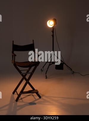 Chaise de réalisateur vide dans un studio sombre illuminé par un seul projecteur. eclairage cinématographique. Banque D'Images