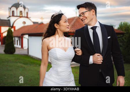 Couple interracial célébrant le jour du mariage avec l'église dans backgr Banque D'Images