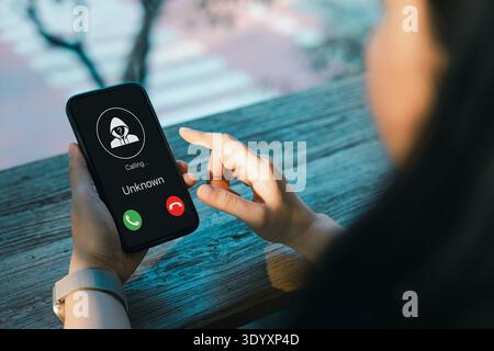 Cybersécurité et concept de sensibilisation à l'arnaque. Femme recevant un appelant inconnu sur l'écran du smartphone, mettant en évidence la fraude téléphonique, le risque de spam, le vol d'identité, Banque D'Images