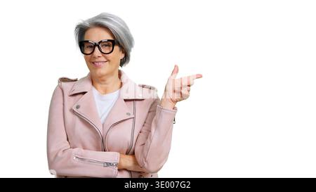 Femme mature souriante pointant doigt montrant l'espace de copie Banque D'Images