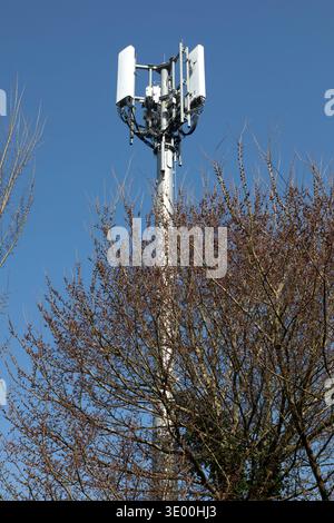 Un mât de communication de téléphone portable contre un ciel bleu clair. Banque D'Images