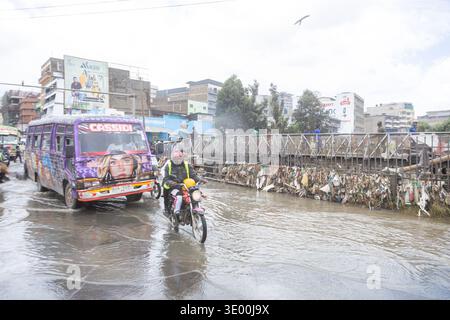 Un motocycliste et un minibus public traversent les eaux de crue le long de Grogan Road près de la rivière Nairobi après une inondation qui a perturbé les entreprises de la région. De fortes pluies ont frappé Nairobi, Kenya, le vendredi 6 mars 2026, déclenché des crues soudaines qui ont submergé les routes et les systèmes de drainage, laissant des parties de la ville submergées et endommageant les entreprises et les véhicules à moteur. À Grogan Road, une plaque tournante très fréquentée pour les pièces de véhicules d'occasion près de la rivière Nairobi, les mécaniciens et les négociants ont continué à récupérer les pièces utilisables après que les inondations ont balayé les garages en bordure de route, les magasins de pièces détachées et les stands le long de la route. Banque D'Images