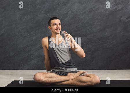Homme de fitness buvant de l'eau au gymnase Banque D'Images