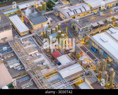 Vue aérienne du complexe industriel avec des tuyaux interconnectés et des réservoirs brillants sous la lumière diffuse du crépuscule, Settecamini, Latium, Italie. Banque D'Images