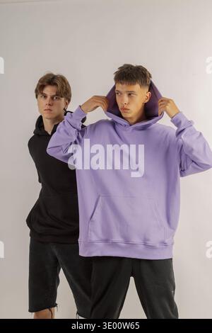 Deux beaux gars avec l'apparence du modèle posent sur un fond blanc dans un studio de photo Banque D'Images