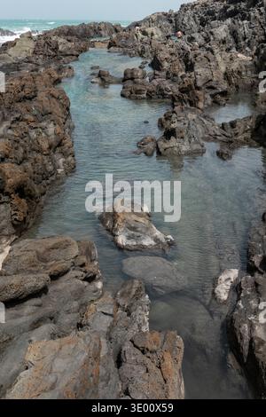 Des piscines naturelles se sont formées entre les roches volcaniques le long de la côte d'Aguas Verdes dans les îles Canaries de Fuerteventura avec de l'eau claire de l'Atlantique et des coas accidentés Banque D'Images