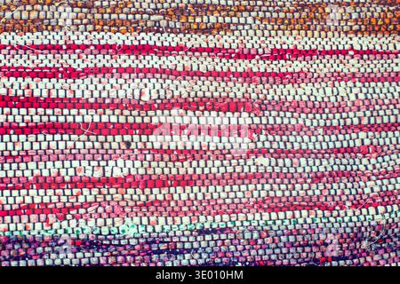 Texture de tapis de chiffon traditionnel tissé à la main rouge et blanc rayé, fond textile rustique Banque D'Images