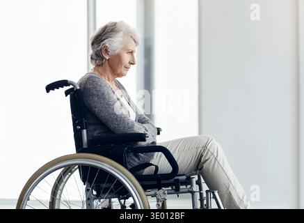 Vieille femme, pensée et perte de mémoire avec fauteuil roulant dans la maison avec démence à la fenêtre, repos et récupération. Personne âgée handicapée, alzheimer et Banque D'Images