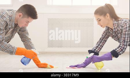 Jeune couple laver le sol ensemble Banque D'Images