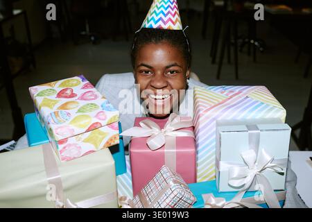Portrait de Black Girl souriant derrière Birthday présente à Celebration Banque D'Images