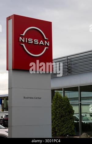 Logo de la marque Nissan sur une grande enseigne rouge sur pylône dans un centre d'affaires moderne et un concessionnaire automobile. Identité de l'entreprise automobile Banque D'Images