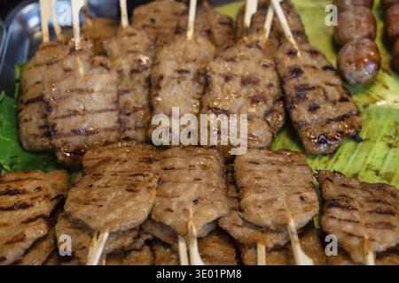 Viande traditionnelle sur bâton, satay de porc grillé ou Moo ping en Thaïlande. Le Moo ping est une collation populaire de Street food à Thaland, disponible sur les marchés nocturnes Banque D'Images