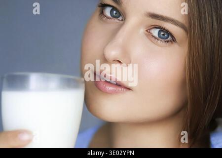 Bonne jeune femme avec un verre de lait ou de lait de protéine shake, boisson de cocktail saine pour le régime et le concept de bien-être Banque D'Images
