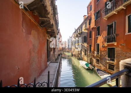 Vue pittoresque sur un canal paisible dans la région de Canaregio à Venise, Italie. Des bâtiments historiques colorés bordent la voie navigable, reflétant le charme de VE Banque D'Images