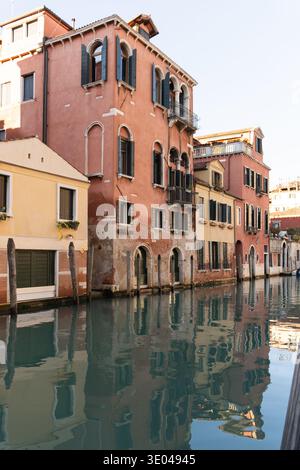 Vue panoramique des bâtiments historiques colorés et des reflets tranquilles dans l'eau à Canaregio, Venise, Italie. La région présente un charmant arc vénitien Banque D'Images