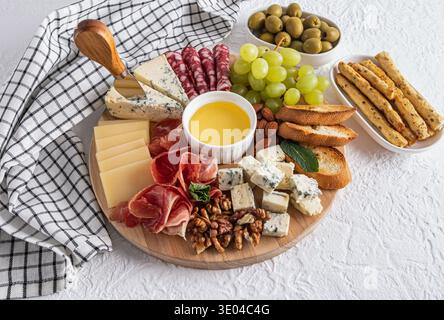 Un plateau de fromages magnifiquement arrangé avec divers fromages, charcuteries, raisins, noix, olives, pain et gressins. Un affichage parfait pour gath Banque D'Images